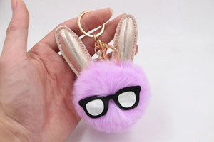 Détail du porte-clés lapin en peluche rose avec oreilles pailletées et fermoir doré