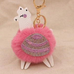 Dettaglio ravvicinato di un portachiavi a forma di alpaca rosa con paillettes e oro