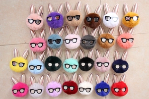 Gros plan de porte-clés lapin en peluche colorés avec oreilles à paillettes et lunettes noires