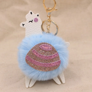 Dettaglio portachiavi alpaca con pompon azzurro e sella con paillettes rosa luccicanti