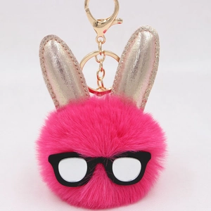 Détail d'un porte-clés lapin en peluche à paillettes avec mousqueton en métal doré