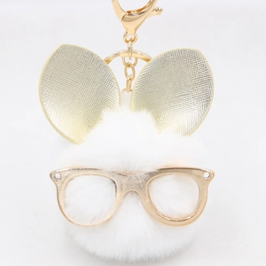 Vue détaillée d'un porte-clés lapin en peluche blanche avec lunettes et oreilles dorées