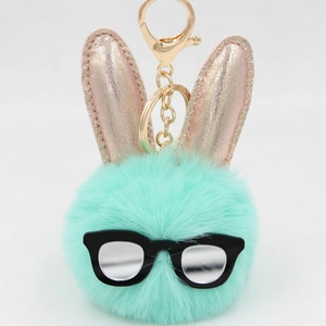 Détail du porte-clés lapin en peluche vert menthe avec oreilles roses et lunettes