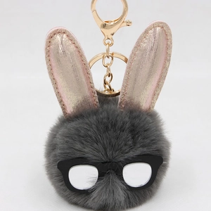 Détail du porte-clés lapin en fausse fourrure grise avec oreilles roses et lunettes