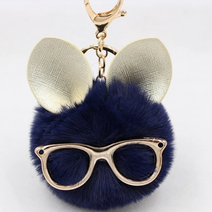 Détail d'un porte-clés en fausse fourrure bleu marine avec lunettes dorées et oreilles de lapin