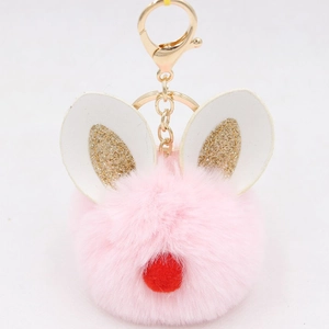 Close-up of pink faux fur pompom keychain with white leather rabbit ears and gold ring
