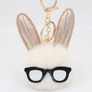 Détail d'un porte-clés lapin en peluche crème avec oreilles roses et lunettes noires