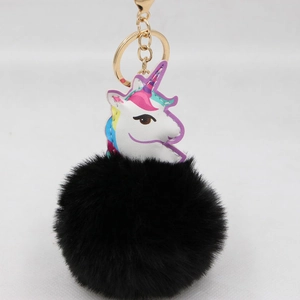 Makroaufnahme von süßem Einhorn-Lederanhänger mit schwarzem Kunstfell-Bommel und Goldring