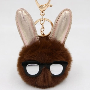 Détail porte-clés lapin en fausse fourrure marron avec oreilles pailletées et clip or