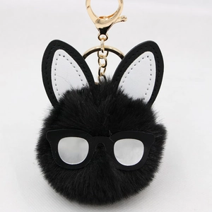 Detail of cute long-eared rabbit plush keychain with black fur and golden lobster clasp