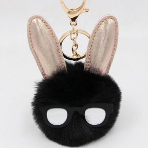 Détail d'un porte-clés lapin en peluche noire avec oreilles or rose et lunettes