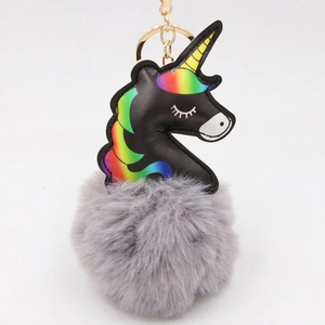 Detail of black leather unicorn keychain with rainbow mane and soft grey plush pompom