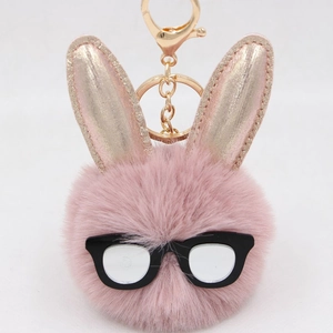 Porte-clés lapin en peluche rose avec oreilles à paillettes et lunettes sur fond blanc