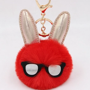 Détail d'un porte-clés lapin en peluche rouge avec oreilles or rose et fermoir