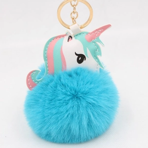 Detail of blue plush pom-pom and stitched unicorn leather charm with golden key ring
