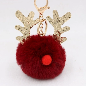 Detail of red faux fur pompom reindeer keychain with golden glitter antlers and gold hook