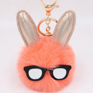 Détail d'un porte-clés lapin en peluche avec oreilles pailletées dorées et lunettes noires