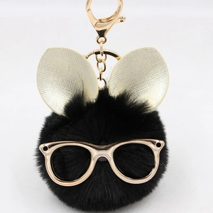 Détail d'un porte-clés lapin noir en peluche avec lunettes dorées et fermoir en métal