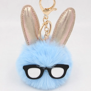Détail du porte-clés lapin en peluche bleue avec oreilles dorées et lunettes noires