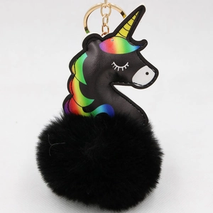 Close-up of black unicorn faux leather detail and soft plush pom pom keychain with gold ring