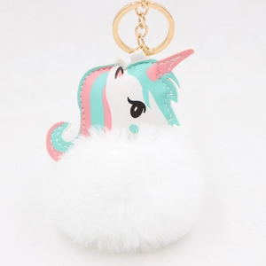 Detail of a white unicorn pom-pom keychain with gold ring and soft faux fur texture