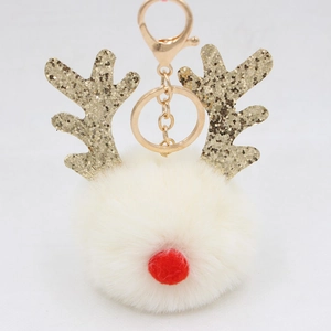 Close-up of cream faux fur ball Christmas reindeer keychain with gold sequin antlers