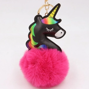 Black leather unicorn keychain with rainbow mane and fluffy pink pom pom on white background
