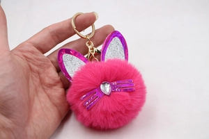 Detailed view of pink plush cat keychain with purple sequin ears and heart gem