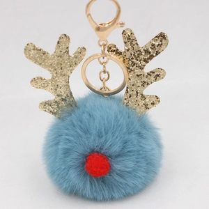 Close-up of a light blue plush reindeer pompom keychain with golden antlers and red nose