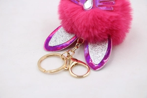 Detailed close-up of pink faux fur keychain with glitter bunny ears and golden metal clasp