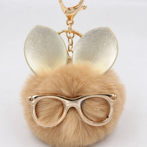 Gros plan du porte-clés tête de lapin en fourrure synthétique avec lunettes dorées