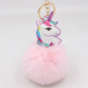 Detailaufnahme von rosa Kunstfell-Bommel und Einhorn-Anhänger mit goldenem Schlüsselring