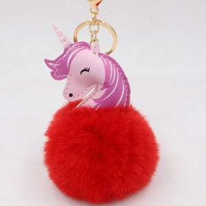 Detail view of the plush red faux fur pompom and the unicorn leather charm with gold clasp