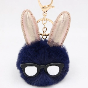 Détail du porte-clés lapin en peluche bleue avec oreilles or rose et lunettes