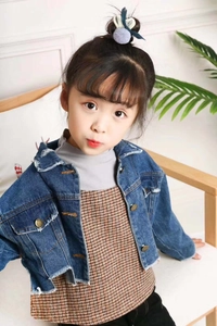 Détail de la veste en jean courte bleu foncé pour filles avec boutons et bords usés
