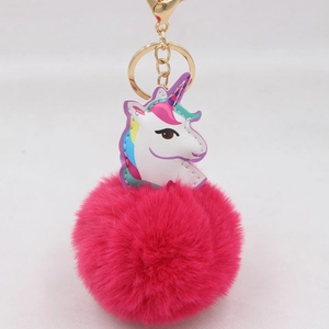 Detail eines weißen Einhorn-Anhängers mit Regenbogen-Textur und fuchsiafarbenem Plüsch-Pompon