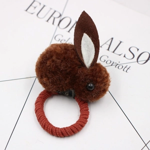 Detailed macro view of a brown plush bunny hair tie with soft faux fur and elastic band