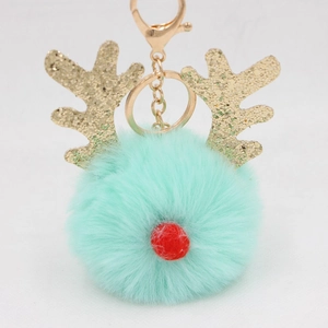 Detail of mint green reindeer pompom keychain with golden sequins and metal clasp
