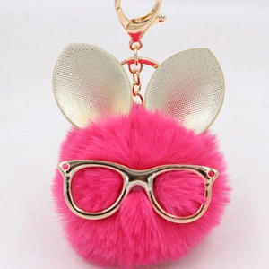 Détail du porte-clés lapin duveteux rouge rose avec lunettes et oreilles dorées