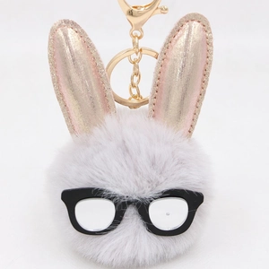 Vue détaillée du porte-clés lapin en peluche avec pompon gris et oreilles dorées
