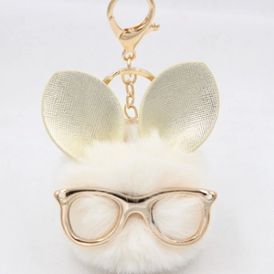 Détail d'un porte-clés lapin en fausse fourrure blanche avec lunettes et oreilles dorées