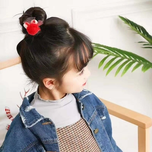 Détail d'une pince à cheveux oreilles de lapin rouge avec pois et nœud sur chignon