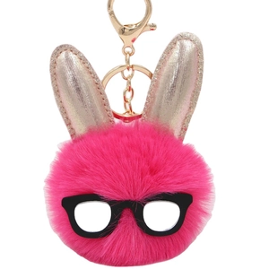 Porte-clés lapin en peluche rose avec lunettes noires et oreilles dorées sur blanc
