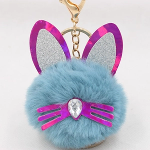 Close-up of cat plush keychain with blue fur, sequin ears and gold metal clasp