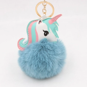 Close-up of white PU leather unicorn head with blue faux fur pompom and gold keyring