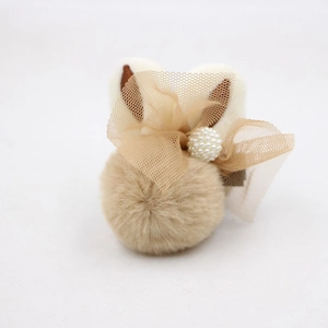 Vue détaillée d'une pince à cheveux oreilles de lapin avec pompon brun et perles