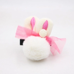 Détail d'une pince à cheveux lapin en peluche avec pompon blanc et nœud en résille