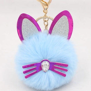 Close-up of sky blue plush cat keychain with sequined ears and a crystal heart