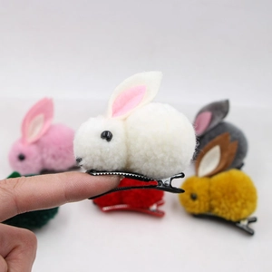 Close-up of a handmade plush rabbit hair clip with soft felt ears and metal duckbill clip