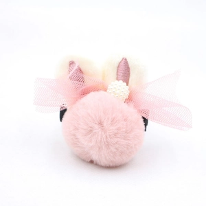 Détail d'un pompon rose en fausse fourrure, oreilles de lapin et perles pour cheveux